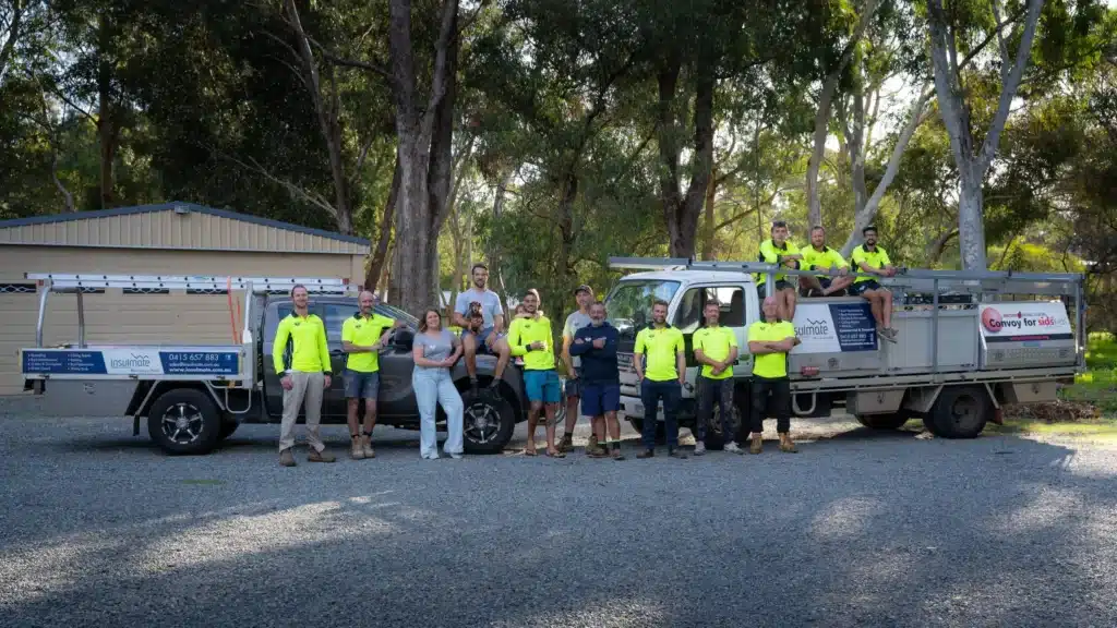 Get a quote with a group of people with two work trucks on a gravel area surrounded by trees