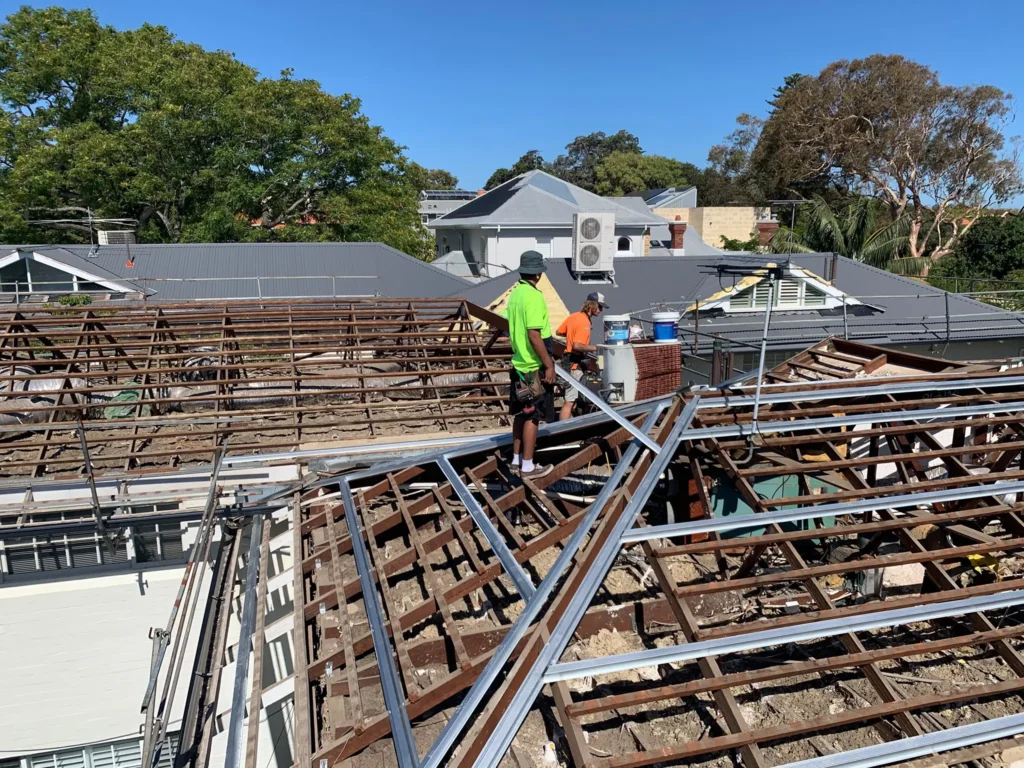 Roof replacement in progress showing exposed timber framing and new metal battens being installed by workers on a residential property in Perth