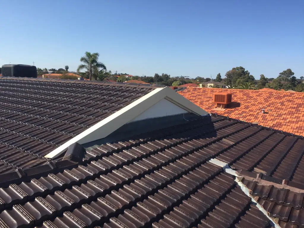 Tiled roof with ridge capping and valley section showing repaired and replaced tiles on a residential home in Perth