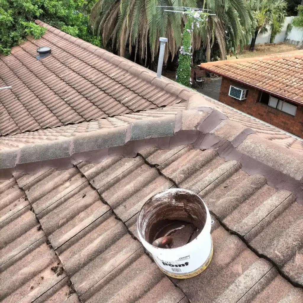 Roof repointing work on tiled roof ridge caps with fresh mortar applied in Perth