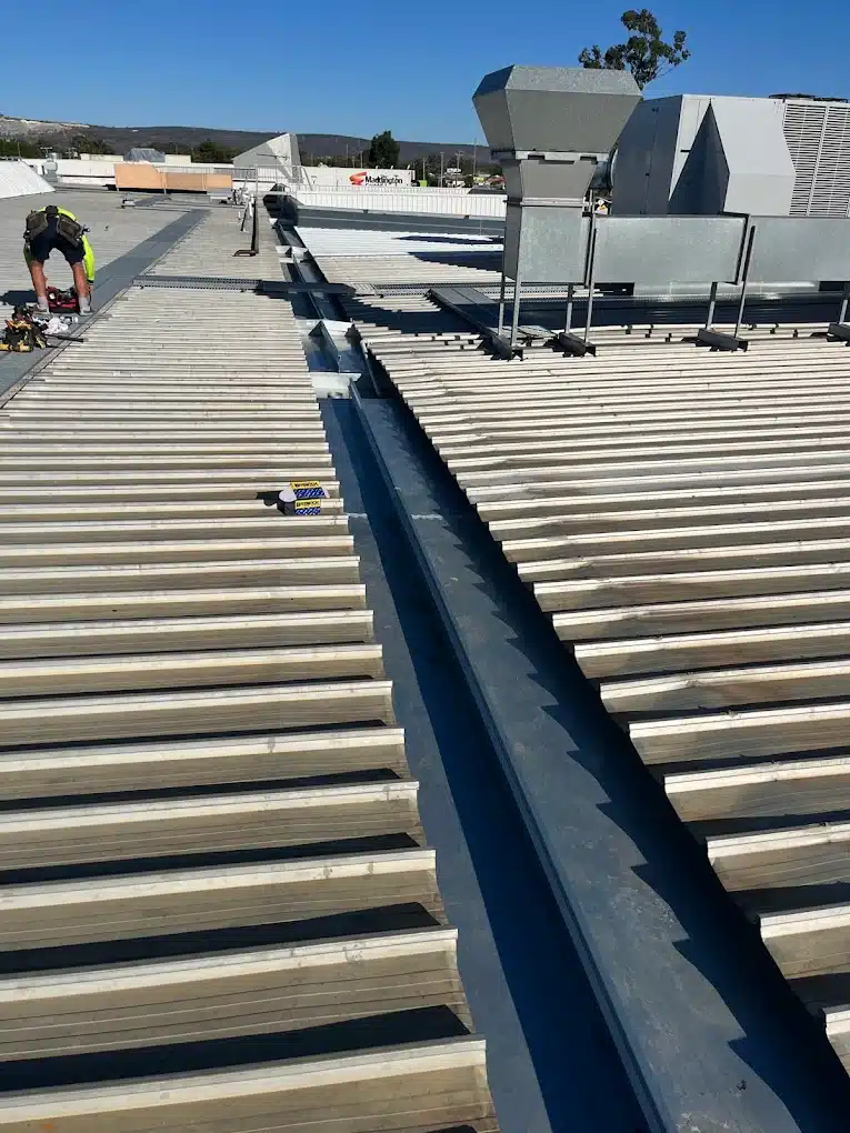 Commercial gutter cleaning service removing debris and improving roof drainage in Perth.