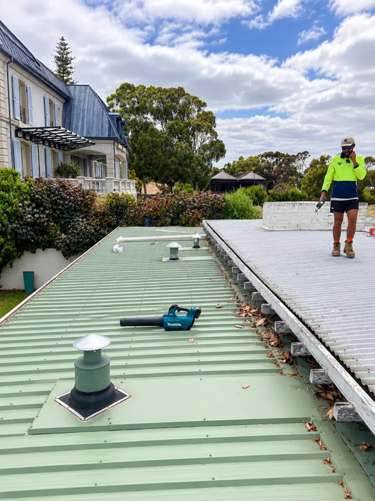 Insulmate Roofing team member inspecting a metal roof in Cottesloe