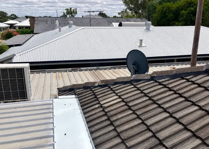 Ridge capping on a concrete tiled roof alongside Colorbond metal roofing, showing different roof materials on residential homes in Perth.